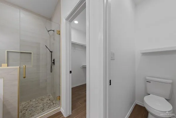 a bathroom with a granite countertop shower and toilet