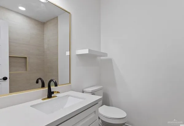 a bathroom with a sink a toilet and mirror