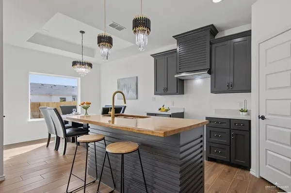 a kitchen with stainless steel appliances a table chairs in it and wooden floors