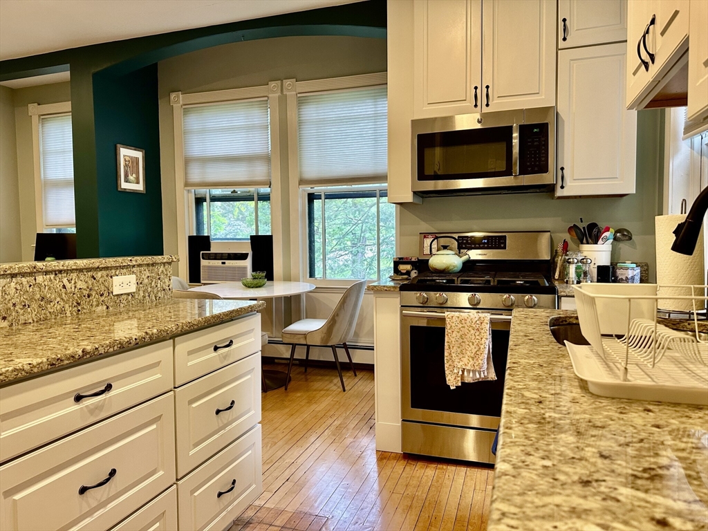 49 Grove Street, Unit 4 Newton, MA 02466 - Photo 14 of 19 a kitchen with stainless steel appliances granite countertop a stove a sink and a microwave