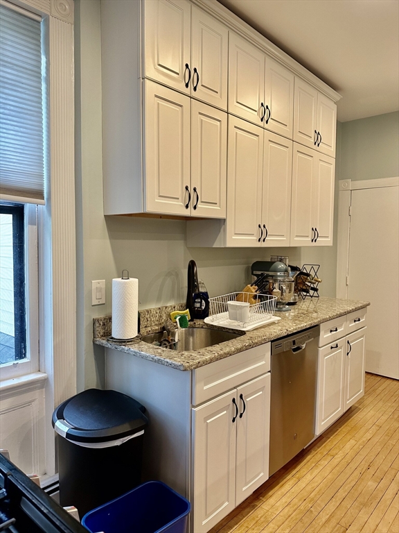 49 Grove Street, Unit 4 Newton, MA 02466 - Photo 17 of 19 a kitchen with stainless steel appliances granite countertop a sink stove and cabinets