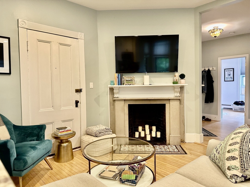 49 Grove Street, Unit 4 Newton, MA 02466 - Photo 5 of 19 a living room with furniture a flat screen tv and a fireplace