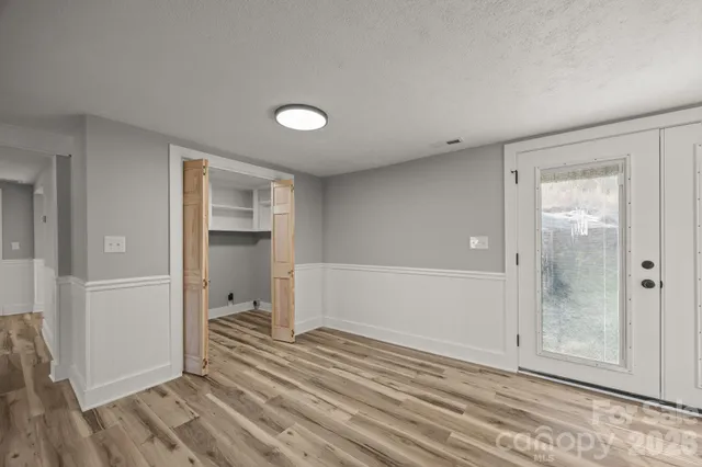 a view of a bedroom with wooden floor and bathroom