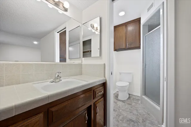 a bathroom with a sink a toilet and mirror