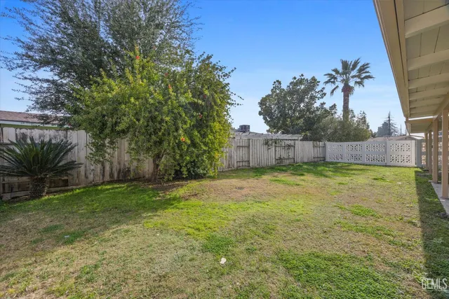 a view of a backyard with wooden fence