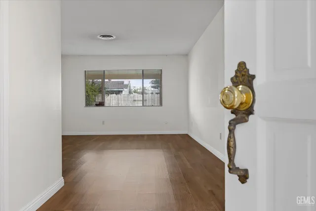 a picture of a room with wooden floor and a window