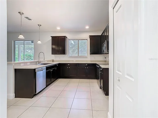 a kitchen with stainless steel appliances a refrigerator sink and microwave