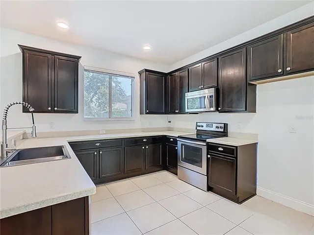 a view of a kitchen with a sink and a refrigerator