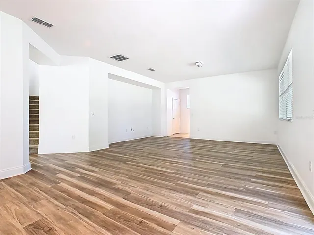 a view of a hallway with wooden floor and entryway
