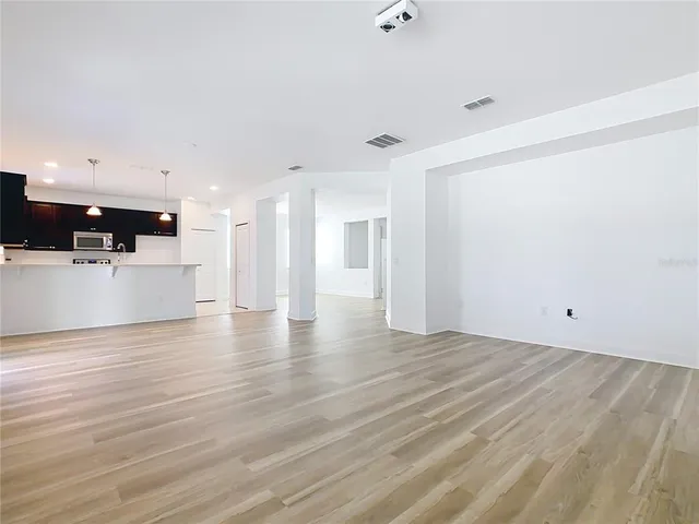 a view of a big room with wooden floor and windows