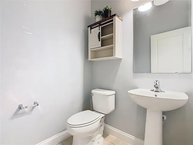 an empty room with wooden floor chandelier fan and windows