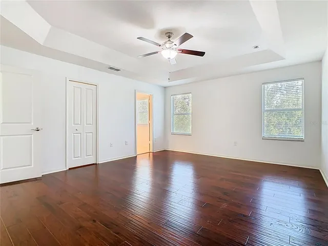 a view of swimming pool with lawn chairs and large trees