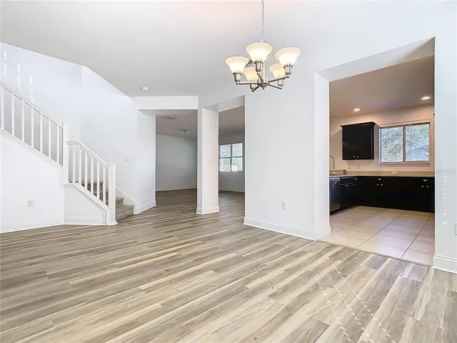 a large white kitchen with a sink and dishwasher a stove with wooden floor