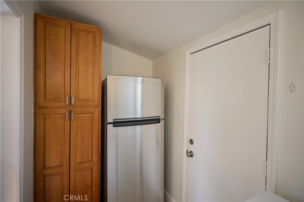 3644 Russell Street Riverside, CA 92501 - Photo 9 of 20 Laundry area complete with pantry, new refrigerator, and back door to back of the unit and garage