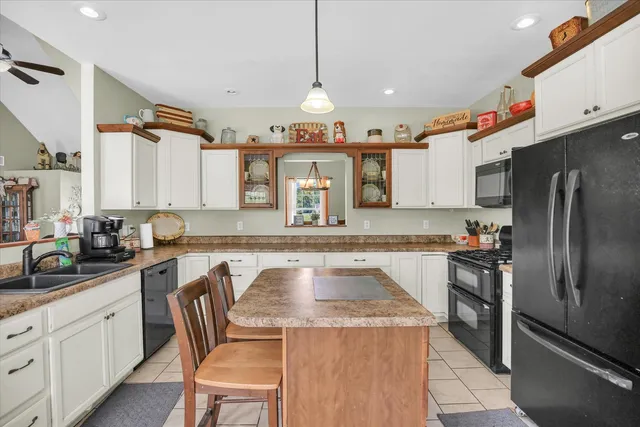 a kitchen with a sink a counter top space appliances and cabinets