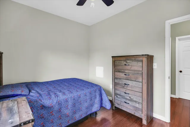 a view of empty room with wooden floor and ceiling fan