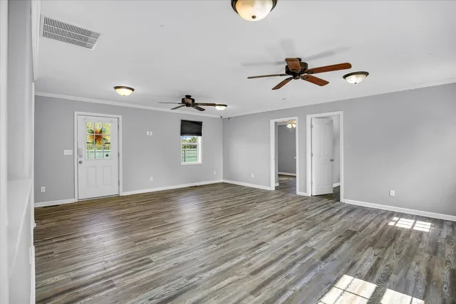 a view of room with a ceiling fan and wooden floor