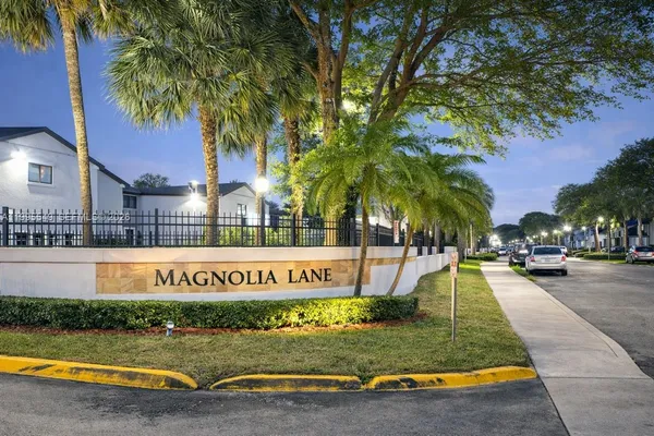 a view of swimming pool with a yard and palm trees