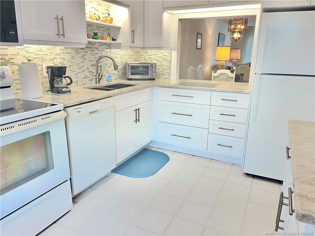 1858 Southwest Palm City Road, Unit 203 Stuart, FL 34994 - Photo 7 of 21 a kitchen with cabinets appliances a sink and a counter space