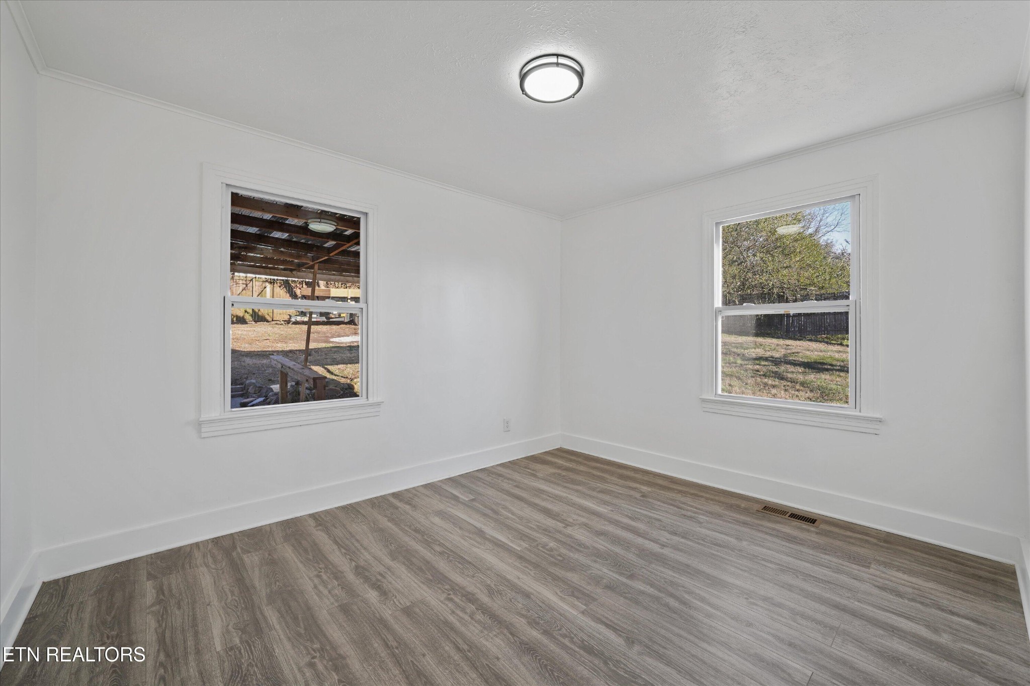 3001 Buffat Mill Road Knoxville, TN 37917 - Photo 12 of 28 a view of an empty room with wooden floor and a window
