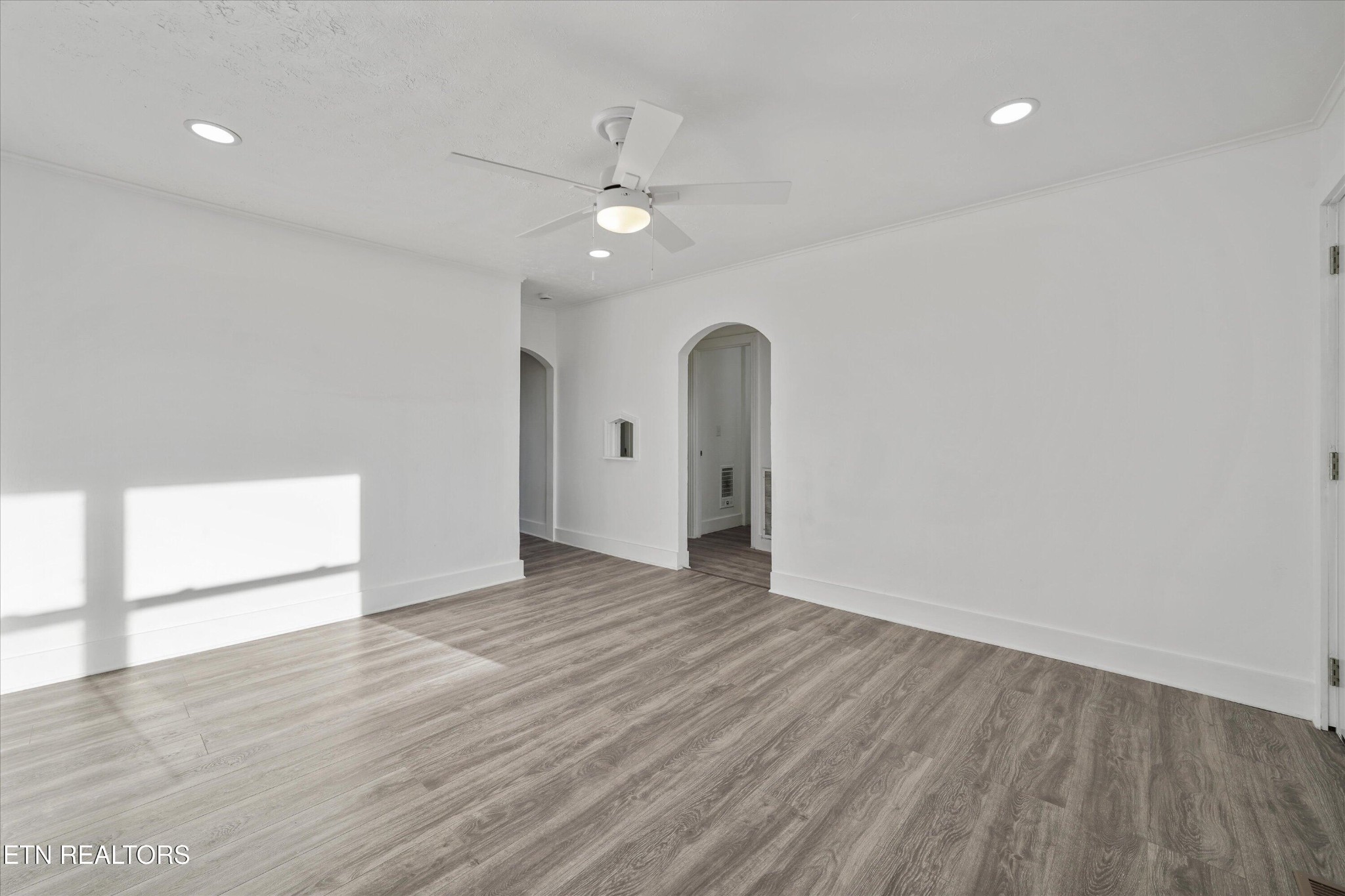 3001 Buffat Mill Road Knoxville, TN 37917 - Photo 5 of 28 a view of an empty room with wooden floor and a ceiling fan