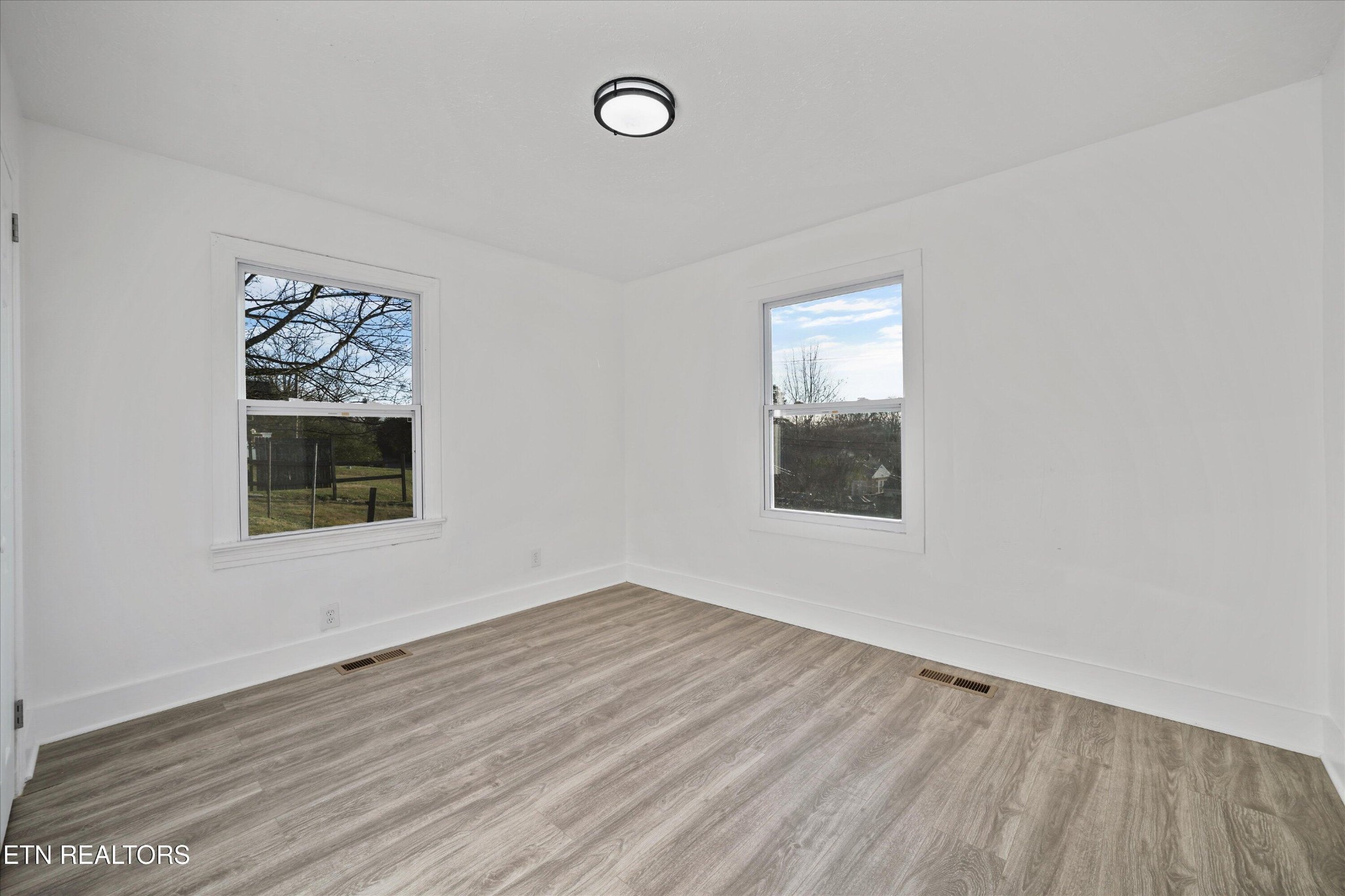 3001 Buffat Mill Road Knoxville, TN 37917 - Photo 8 of 28 an empty room with wooden floor and windows