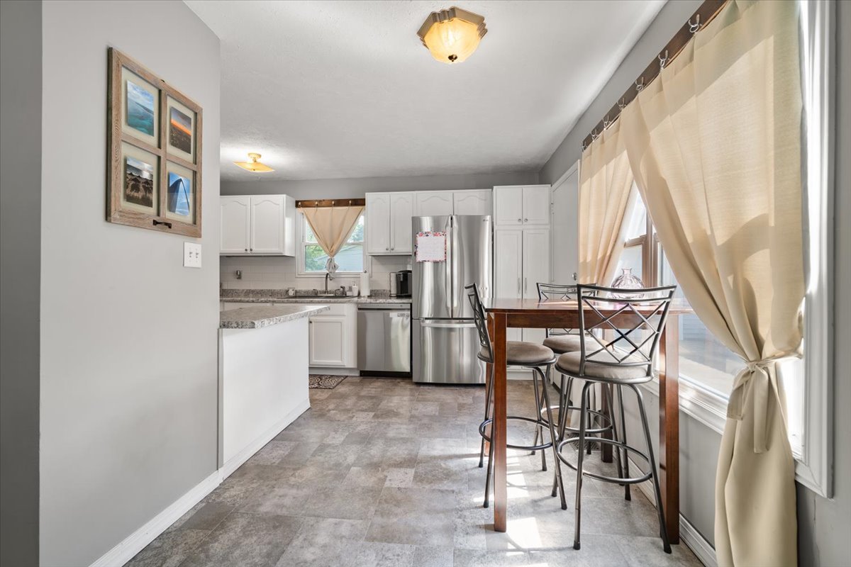 1907 Cloud Street Bloomington, IL 61701 - Photo 7 of 27 a kitchen with a table chairs refrigerator and cabinets