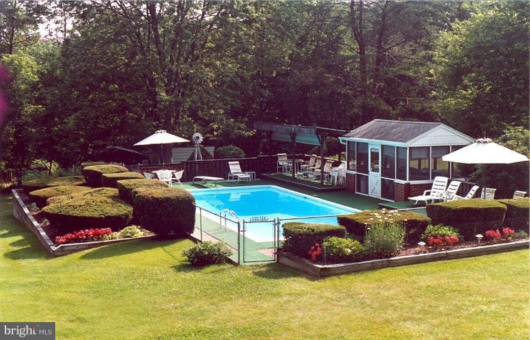 7932 Johnnycake Road Windsor Mill, MD 21244 - Photo 1 of 23 a view of a patio with table and chairs under an umbrella