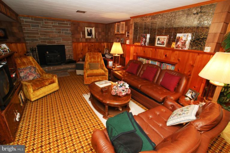 7932 Johnnycake Road Windsor Mill, MD 21244 - Photo 21 of 23 a living room with furniture a fireplace and a dining table