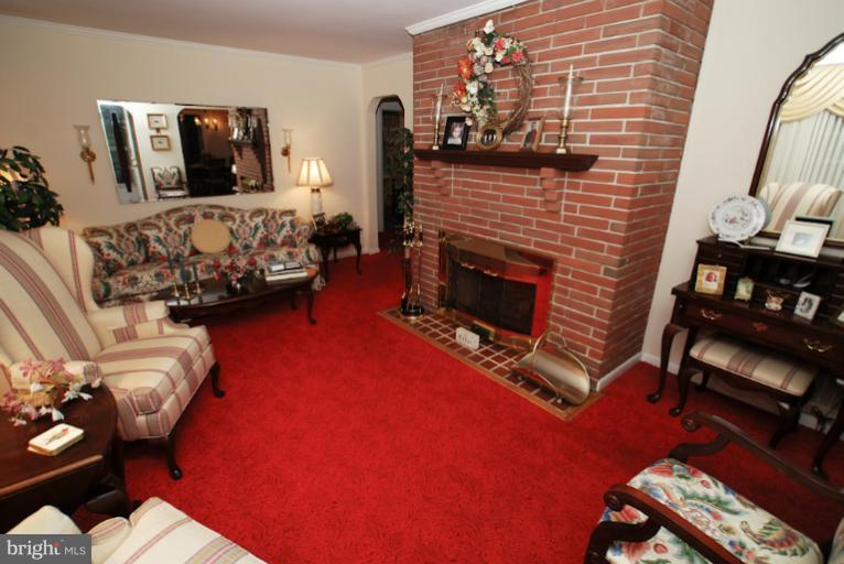 7932 Johnnycake Road Windsor Mill, MD 21244 - Photo 6 of 23 a living room with furniture a flat screen tv and a fireplace