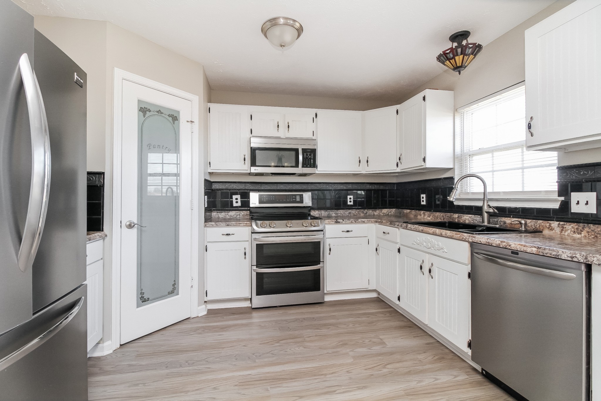 7015 Zither Lane La Vergne, TN 37086 - Photo 6 of 17 a kitchen with stainless steel appliances granite countertop a stove a refrigerator and a microwave