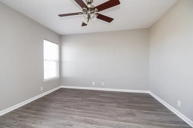 wooden floor in an empty room with a window