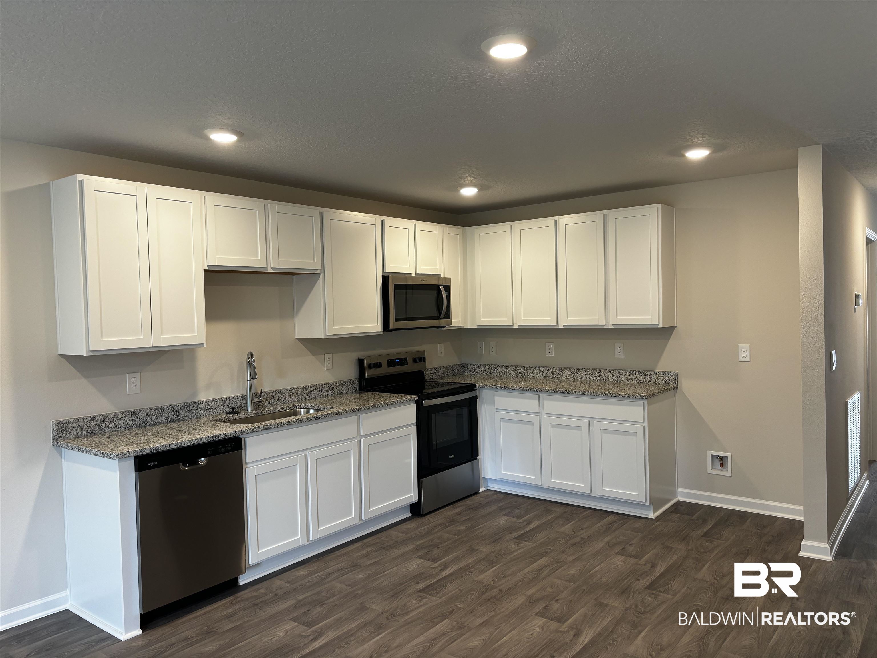 1036 South Bay Street Foley, AL 36535 - Photo 20 of 32 Kitchen featuring appliances with stainless steel finishes, white cabinetry, sink, and dark wood-type flooring