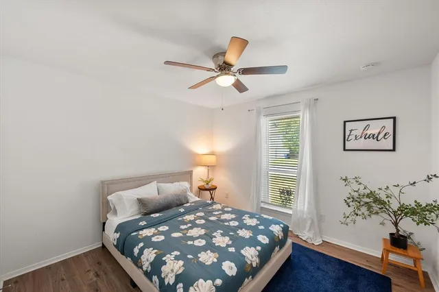 a bed sitting in a bedroom next to a window and a wooden floor