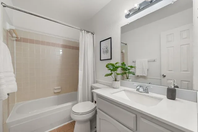 a bathroom with a shower sink vanity mirror and toilet