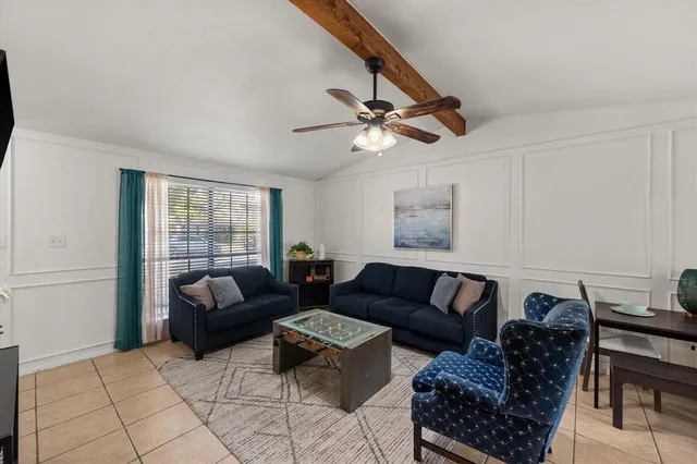 a living room with furniture a ceiling fan and a window