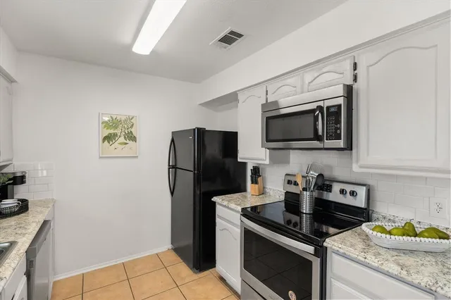 a kitchen with a refrigerator and a stove top oven