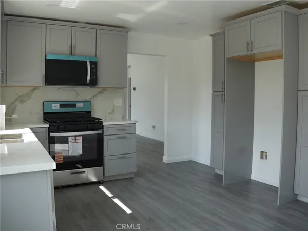 a kitchen with granite countertop a stove and a microwave
