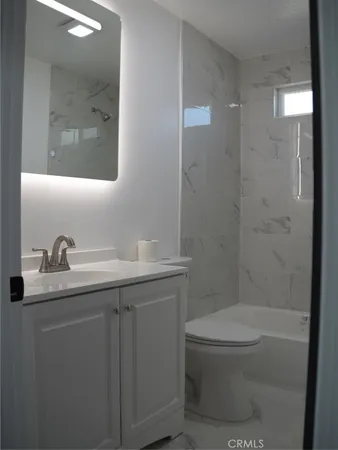 a bathroom with a toilet sink shower and mirror