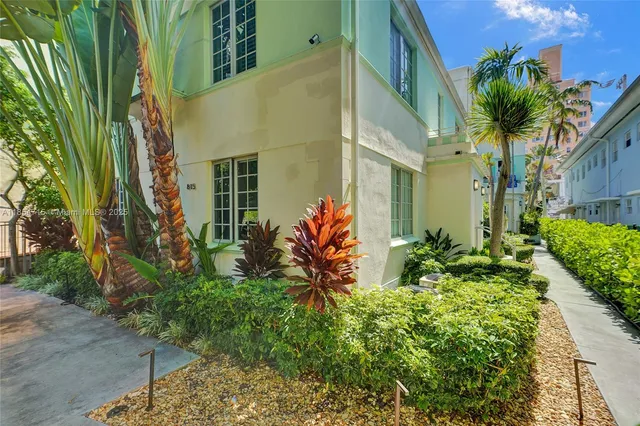 a view of backyard of white house with a large garden