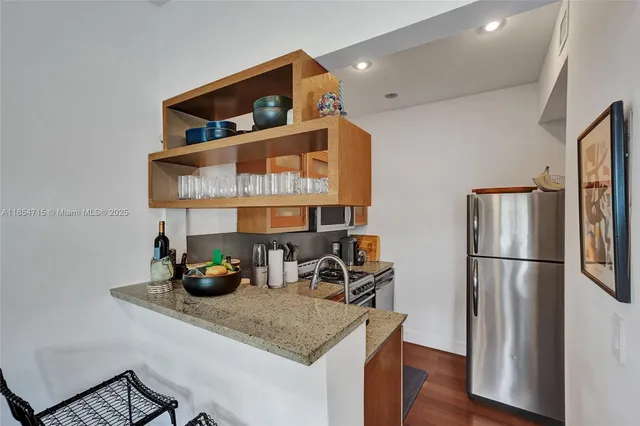 a kitchen with a refrigerator a stove and wooden floor