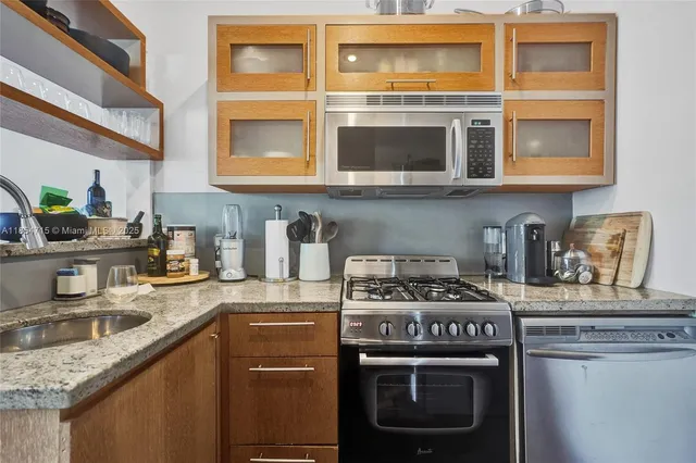 a kitchen with stainless steel appliances granite countertop a stove and a microwave