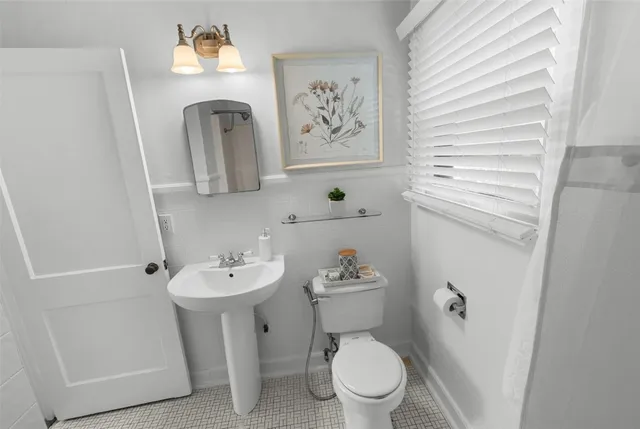 a bathroom with a toilet sink and mirror