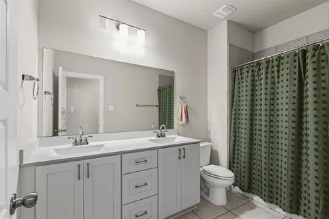 a bathroom with a double vanity sink toilet and a mirror