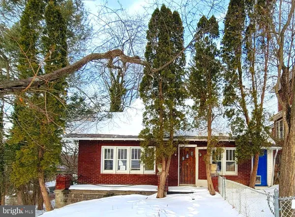 a front view of a house with a tree