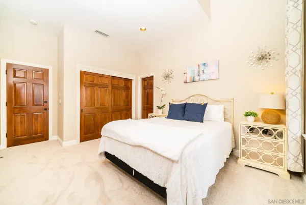 a spacious bedroom with a bed a chair and potted plant with the outer view