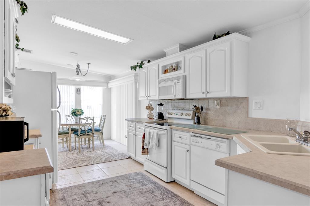 2405 Kelly Sebastian, FL 32958 - Photo 3 of 17 a kitchen with a sink white cabinets and white appliances