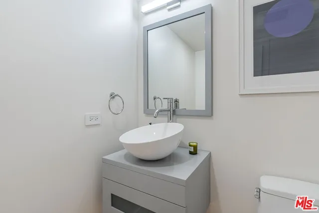 a bathroom with a sink a toilet and mirror