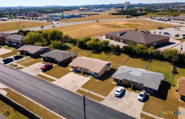 an aerial view of residential houses with outdoor space and ocean view