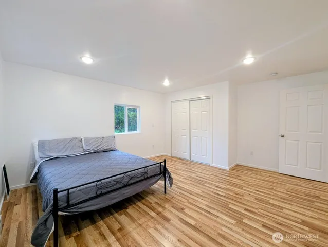 a bedroom with a bed and wooden floor